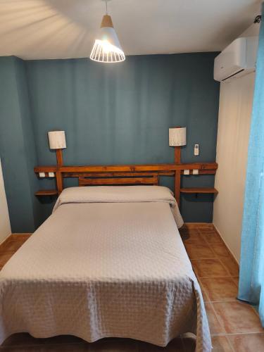 a bedroom with a bed and a blue wall at Casa MªÁngeles in Puebla de Arenoso