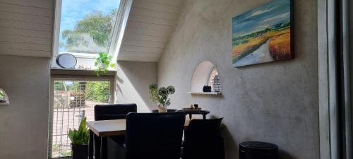 a dining room with a table and chairs and a window at 't Achterhuis in Alteveer