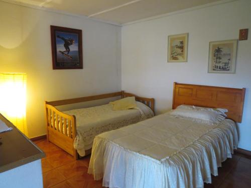 a bedroom with two beds and a table with a lamp at Posada Verde Natura in Viña del Mar