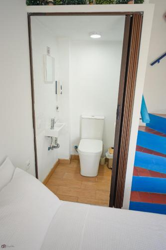 a bathroom with a white toilet and a sink at Casa Edison in Conil de la Frontera