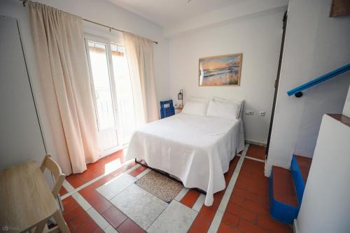 a bedroom with a white bed and a window at Casa Edison in Conil de la Frontera