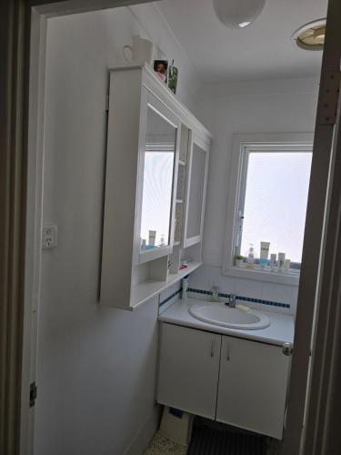 a white bathroom with a sink and a window at Girrawheen3 - Room in a Shared House in Perth
