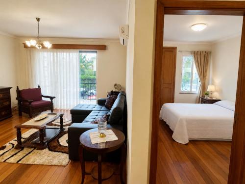a living room with a couch and a bed at Cantinho de Santa Teresa in Canhas