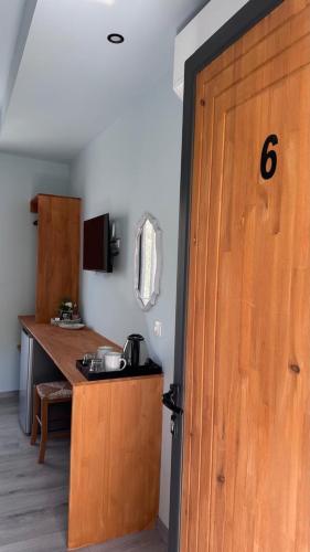 a kitchen with a wooden door next to a counter at Palms Guest House in Himare
