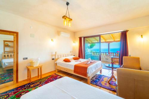 a bedroom with a bed and a chair and a window at Istlada Taş Ev Apart - Kekova Island View in Demre