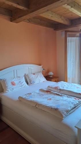 a white bed in a room with a window at B&B Hannelore in Vilminore