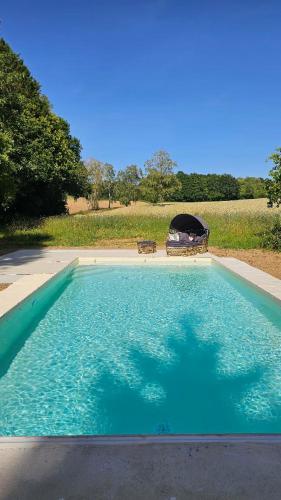 a large pool of blue water with a gazebo at Gîte de plain-pied sans escaliers, Dordogne in Firbeix