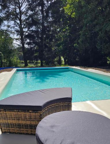 a swimming pool with blue water in a backyard at Gîte de plain-pied sans escaliers, Dordogne in Firbeix
