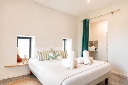 a bedroom with a white bed with green curtains at Petit Albert, confortable, proche de La Rochelle in Aytré