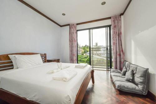 a bedroom with a bed and a chair and a window at Skyline Seaview Villa-5 Bedroom, 4 Bathrooms with Private Seaview Pool in Ban Thong Phlu