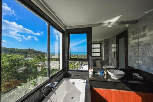 a bathroom with a tub and a sink and a window at Skyline Seaview Villa-5 Bedroom, 4 Bathrooms with Private Seaview Pool in Ban Thong Phlu