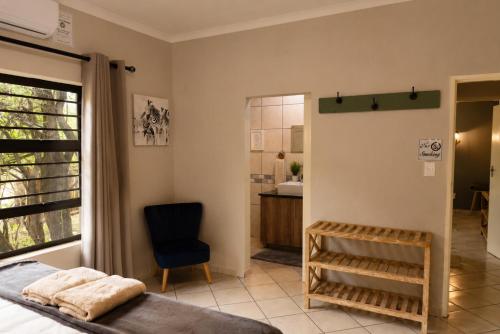 a bedroom with a bed and a bathroom at Maningwe in Marloth Park