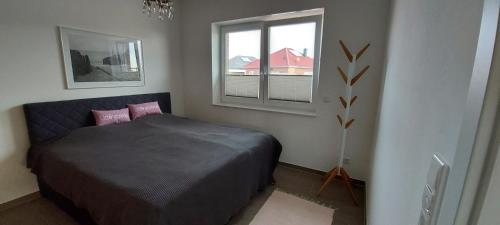 a bedroom with a bed and a window at Haus Admaris am Wangermeer in Wangerland