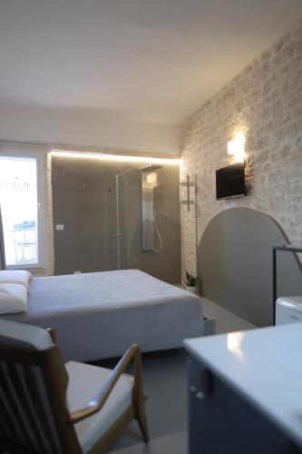 a bedroom with a bed and a chair and a mirror at Pepenero Apulian Rooms in Noci