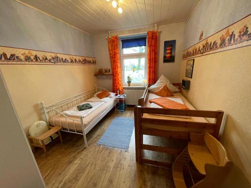 a small room with two beds and a window at Bluhm EG in Wangerland