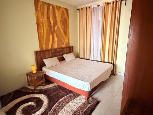 a small bedroom with a bed and a night stand at Fitini appart in Bamako