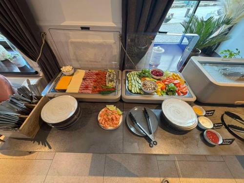ein Tisch mit einem Buffet und Tellern mit Essen in der Unterkunft Old Mill Comfort in Klaipėda