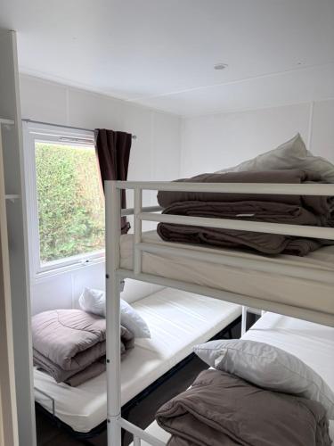 a room with three bunk beds and a window at Bungalow Camping 4 étoiles in Messanges