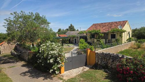 a house with a gate and a stone fence at Krka Hideaway in Lozovac