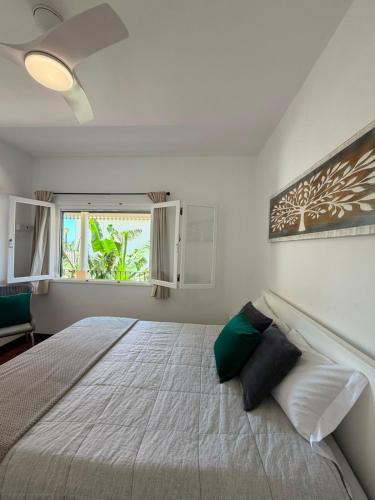 a bedroom with a large bed and a window at Maresia's House, Madalena do Mar in Madalena do Mar