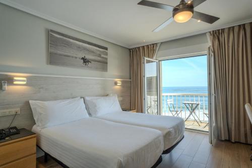 a hotel room with a bed and a balcony at Hotel Silken Don Pepe y Don Pepe Ría in Ribadesella