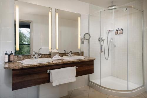 a bathroom with two sinks and a shower at Aghadoe Heights Hotel & Spa in Killarney