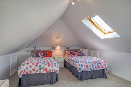 a attic bedroom with two beds and a skylight at Heddfan Cottage in Haverfordwest