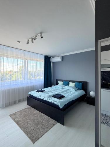 a bedroom with a bed and a blue wall at RVR Apartmanhàz in Sárospatak
