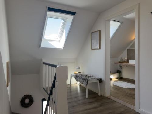 a room with a staircase with a skylight at Haus mit Herz in Wangerland