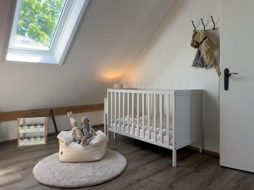 a baby room with a crib and a window at Haus mit Herz in Wangerland