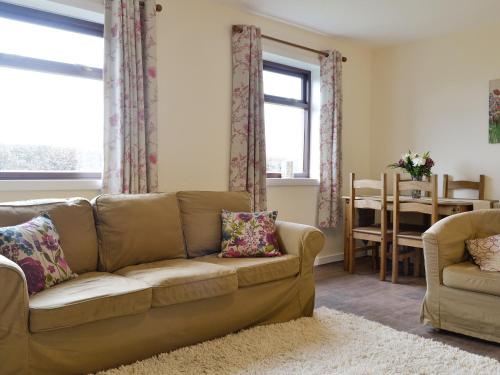 a living room with a couch and a chair at Beuchan Bungalow in Closeburn