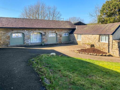 a house with two garage doors and a driveway at Stable End in Llandysul