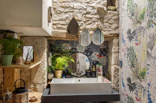 a kitchen with a sink and a mirror at La Grange des zarts in Champagné-le-Sec