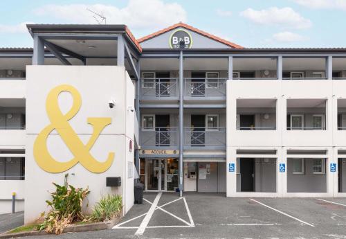 a large white building with a logo on it at B&B HOTEL Bayonne in Bayonne