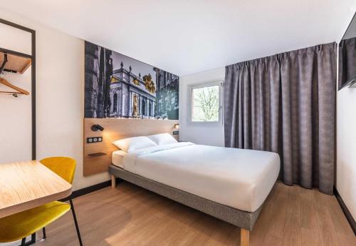 a hotel room with a white bed and a window at B&B HOTEL Lille Roubaix Centre Grand-Place in Roubaix