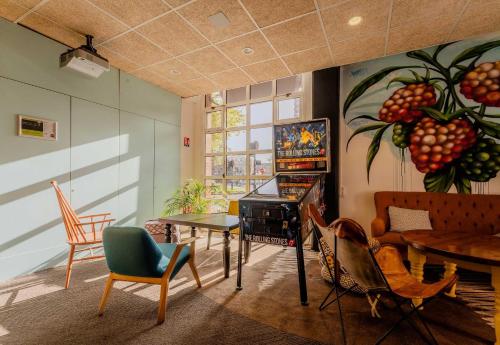 a living room with chairs and a table and a painting at B&B HOTEL Lille Roubaix Centre Grand-Place in Roubaix