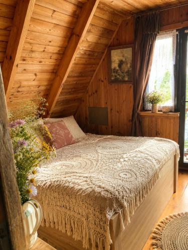 a bedroom with a bed in a wooden house at Magiczny Dom nad Bugiem in Pętkowo Wielkie