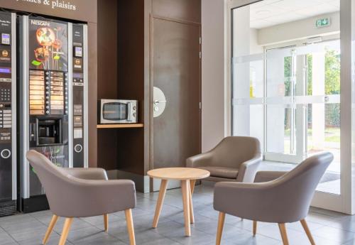 a waiting room with two chairs and a table at B&B HOTEL Lyon Eurexpo Chassieu in Chassieu