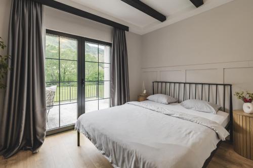 a bedroom with a large bed and a large window at Kami The Essence in Danilovgrad