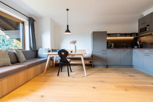 a living room with a table and a kitchen at Gästehaus Strasser in Riezlern