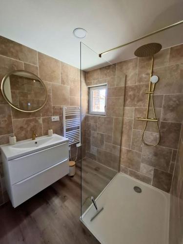 a bathroom with a tub and a sink and a shower at Les 3 suites in Issoire