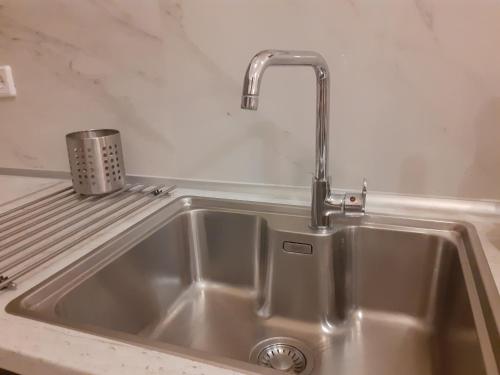 a stainless steel sink with a faucet on a counter at ELENI'S HOUSE FOR VACATION in Nea Plagia
