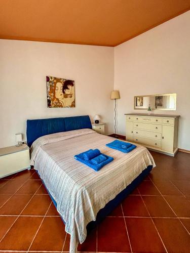 a bedroom with a bed with blue pillows on it at Amazing house 10 minutes by car from the beach in Olbia