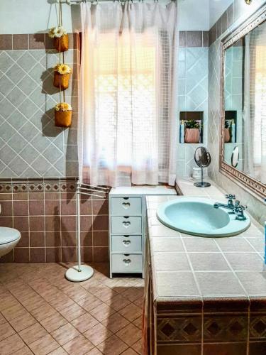 a bathroom with a tub and a sink and a mirror at Amazing house 10 minutes by car from the beach in Olbia
