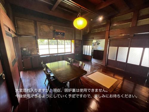 a dining room with a table and chairs at 一棟貸し古民家赤ちゃんから楽しめる文化庁選定重要伝統的建造物 築130年"古民家ゆうなぎ"小松空港から35分 金沢から60分 in Kaga