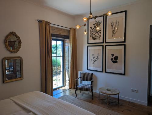 a bedroom with a bed and a chair and a window at Maison Mazille in Mazille