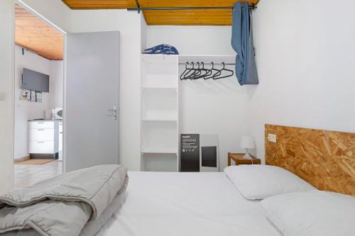 a bedroom with white walls and a bed with white sheets at 16. Les Sources option clim- 2 pers in Calviac