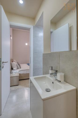 a white bathroom with a sink and a mirror at Private Room in Hamrun HMR006 in Hamrun
