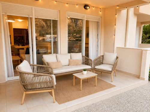 a porch with two chairs and a couch and a table at Kotor Bay View Residence with Pool in Muo