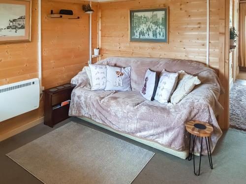 a living room with a couch in a wooden room at Algwen Cabin in West Walton